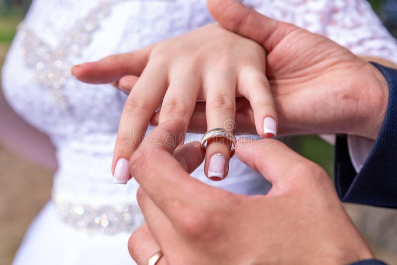 ?lska f?rbindelsen br?llop f?r brudceremoniblomma Stäng sig upp av brudgummen som sätter den guld- cirkeln på bride&en x27; s-fin fotografering för bildbyråer ?lska f?rbindelsen br?llop f?r brudceremoniblomma Stäng sig upp av brudgummen som sätter den guld- cirkeln på bride&en x27; s-fin fotografering för bildbyråer