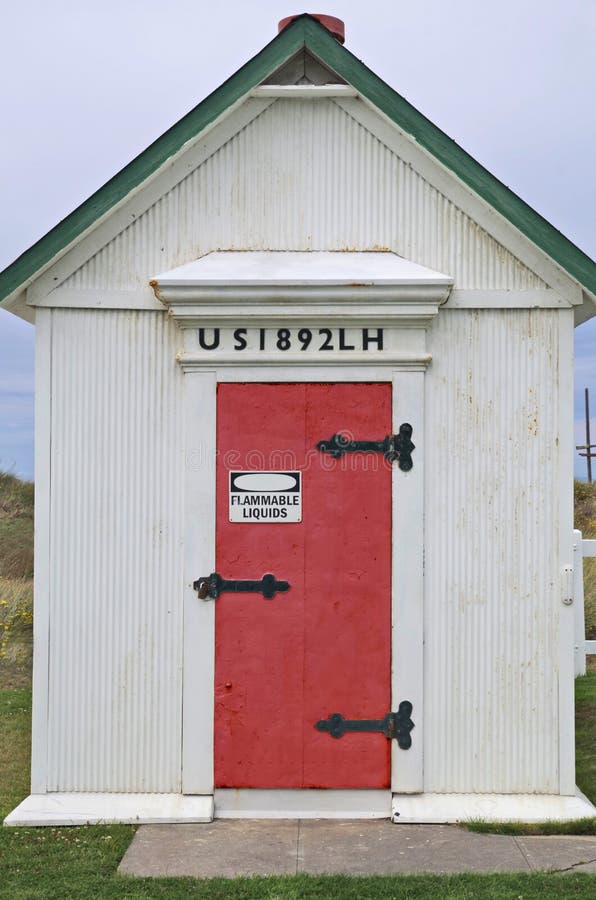 The Oil House at the Lighthouse at Dungeness Spit near Sequim Washington state. Fuel oil used by the lighthouse in stored here. Rusty Red door. Sign says Flammable Liquids. The Oil House at the Lighthouse at Dungeness Spit near Sequim Washington state. Fuel oil used by the lighthouse in stored here. Rusty Red door. Sign says Flammable Liquids.