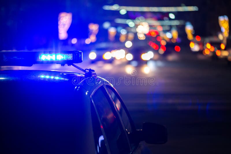 Luces del coche policía en la noche en ciudad con el foco selectivo y el bokeh