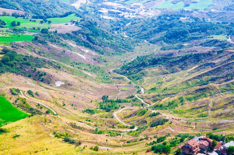Lucht hoogste panorama van landschap met weg in vallei, groene heuvels, gebied en bossen van Republiek San Marino stock afbeelding Lucht hoogste panorama van landschap met weg in vallei, groene heuvels, gebied en bossen van Republiek San Marino stock afbeelding