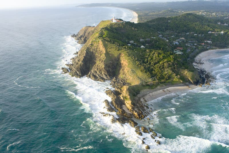 Aerial view of waves breaking on Byron Bay with lighthouse on cliffs, New South Wales, Australia. Aerial view of waves breaking on Byron Bay with lighthouse on cliffs, New South Wales, Australia.