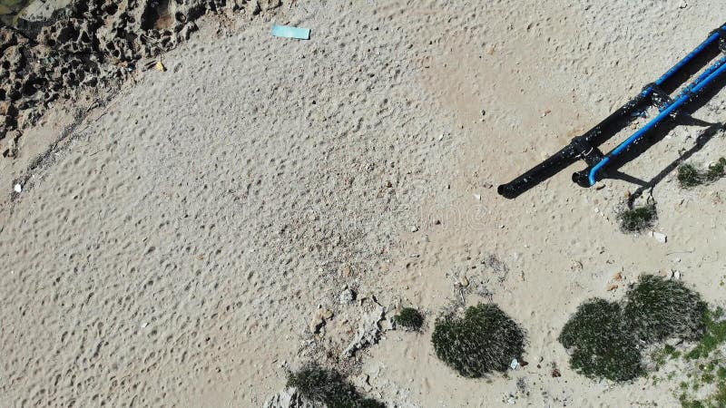 Luchtdiebovenkant over zandig strand met de plastic flessen van het afvalafval wordt geschoten Vuil zandig rotsachtig strand met