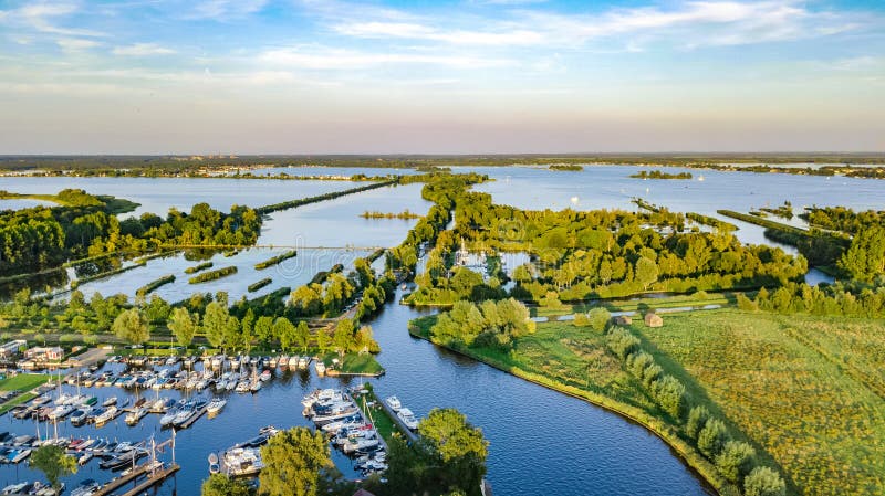 Luchthommelmening van typisch Nederlands landschap met het water van de groene velden en landbouwbedrijfhuizen kanalenpolder van N