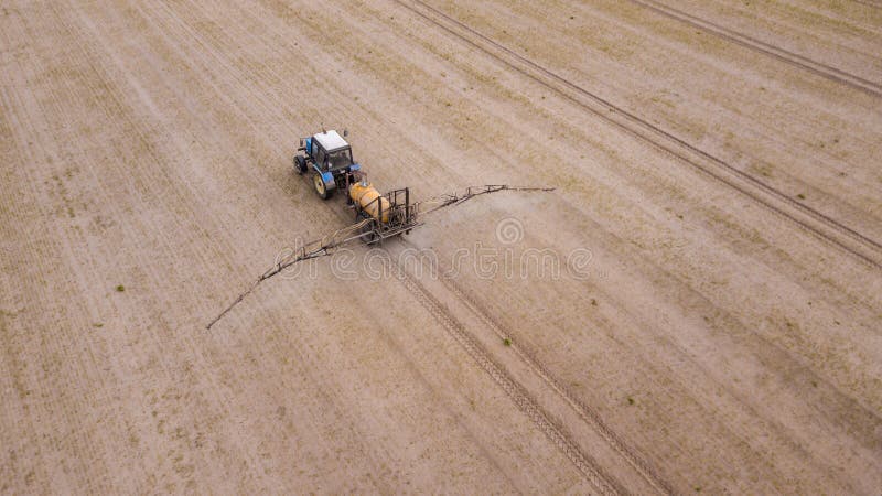 Luchtmening van de landbouw van tractor die en op gebied ploegen bespuiten royalty-vrije stock foto Luchtmening van de landbouw van tractor die en op gebied ploegen bespuiten royalty-vrije stock foto