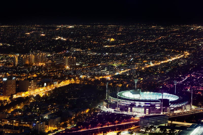Luchtnachtmening van de Veenmolgrond en stad van Melbourne bij nacht stock afbeeldingen Luchtnachtmening van de Veenmolgrond en stad van Melbourne bij nacht stock afbeeldingen