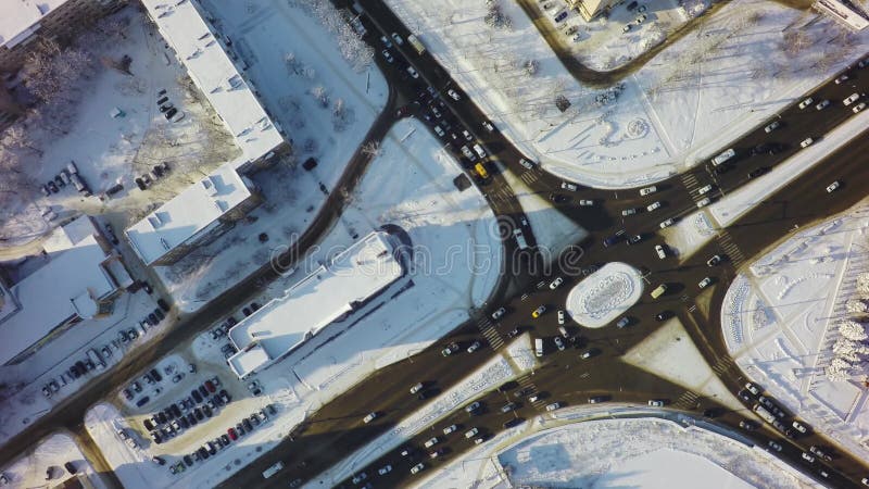 Luchttop down mening van kruising in de winter, cirkelkruispunt met verkeer en sneeuw