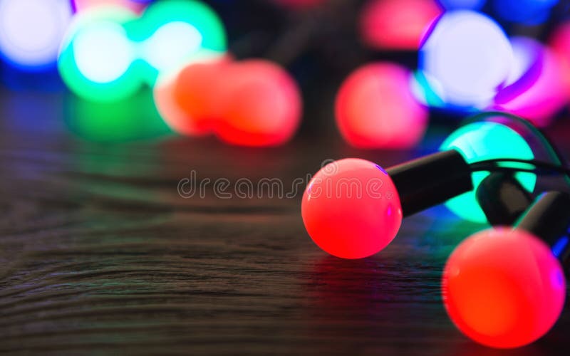 Luci di Natale Colourful che emettono luce sul fondo scuro fotografia stock Luci di Natale Colourful che emettono luce sul fondo scuro fotografia stock
