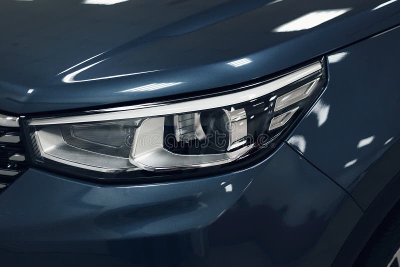 Luci di testa di una moderna auto a colori blu Dettagli sulla luce anteriore di un'auto Concetto di auto moderne e costose L'auto è in salotto Concetto automobilistico Colore blu classico