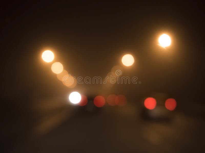 Luci vaghe delle automobili sulla strada nella nebbia immagini stock libere da diritti Luci vaghe delle automobili sulla strada nella nebbia immagini stock libere da diritti