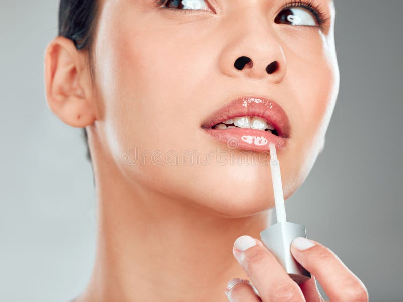 Lucidalabbra di trucco e cosmetici con lucidalabbra di donna in studio per l'umidificatore per labbra ed estetica. pelle di collag immagine stock libera da diritti