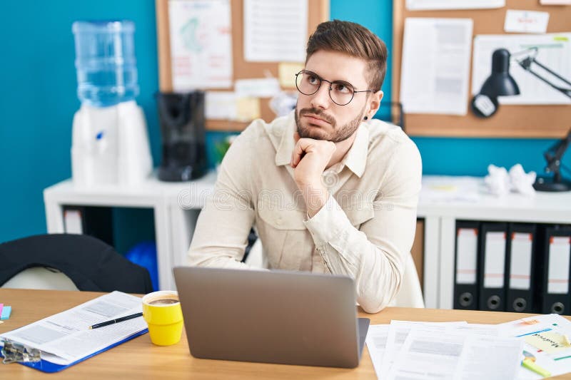 Lucrător tânăr caucazian pentru afaceri care utilizează un laptop care lucrează la birou stock image