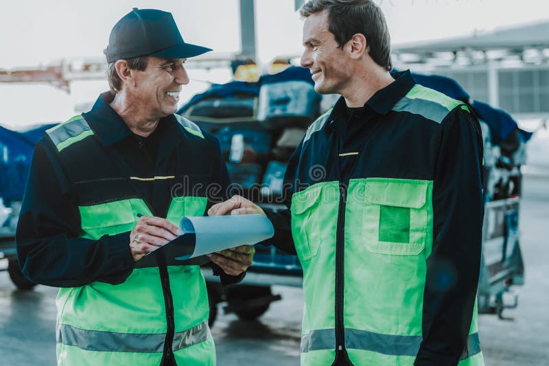 Lucrători zâmbitori care au un loc de muncă pe aerodrom stock photos