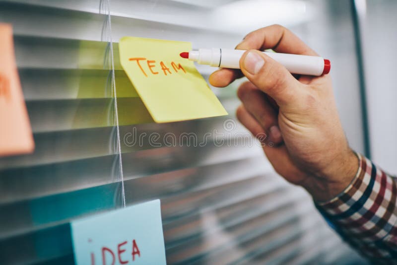 Lucrătorul masculin cu fațete care face note pe hârtie stock photos