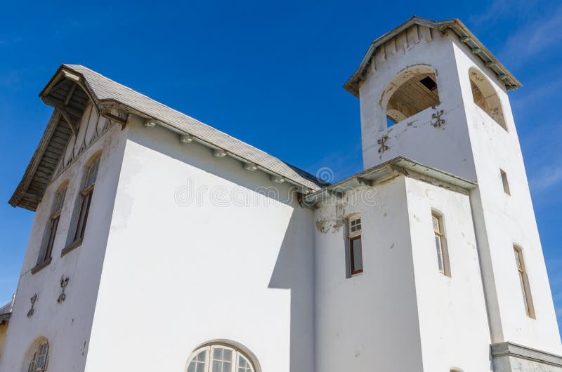 Luderitz, Namíbia - 8 de julho de 2014: Ministério de alojamento branco histórico da igreja de Envrionment e de turismo imagens de stock Luderitz, Namíbia - 8 de julho de 2014: Ministério de alojamento branco histórico da igreja de Envrionment e de turismo imagens de stock