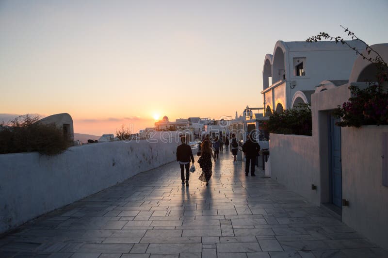 Ludzie Chodzi w kierunku zmierzchu z Dennym widokiem w Oia, Santorini, obraz royalty free Ludzie Chodzi w kierunku zmierzchu z Dennym widokiem w Oia, Santorini, obraz royalty free