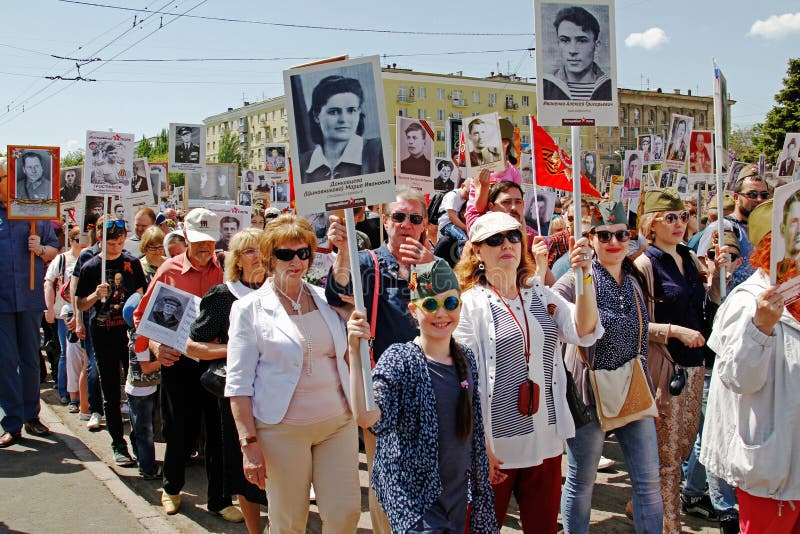 Ludzie chwytów portretów ich krewni w akci ` pułku Nieśmiertelnym ` na zwycięstwo dniu w Volgograd obraz stock Ludzie chwytów portretów ich krewni w akci ` pułku Nieśmiertelnym ` na zwycięstwo dniu w Volgograd obraz stock