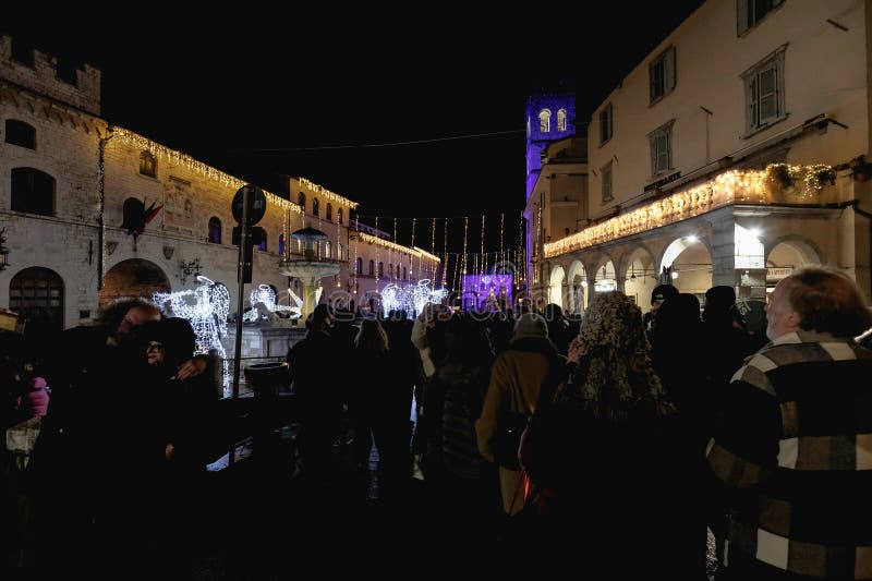 Assisi, Italy - January 1, 2024: people partying in the main square of the city for New Year's Eve at night with fireworks and a concert. Assisi, Italy - January 1, 2024: people partying in the main square of the city for New Year's Eve at night with fireworks and a concert