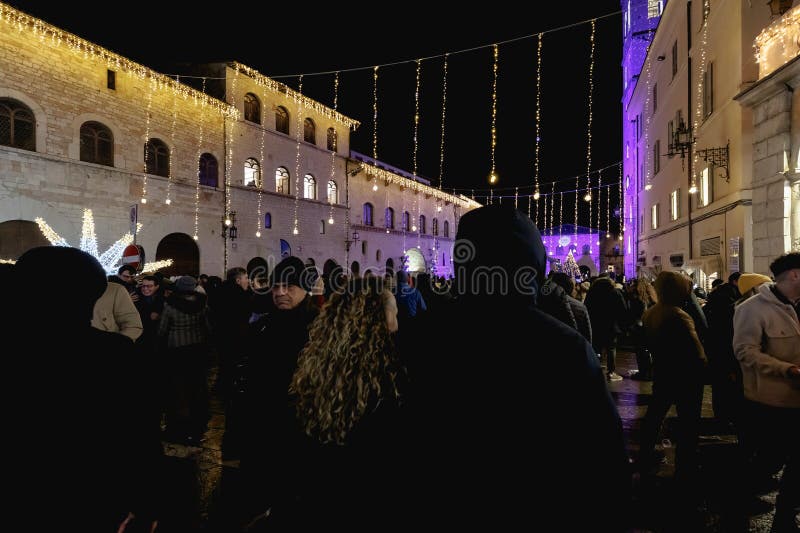 Assisi, Italy - January 1, 2024: people partying in the main square of the city for New Year's Eve at night with fireworks and a concert. Assisi, Italy - January 1, 2024: people partying in the main square of the city for New Year's Eve at night with fireworks and a concert