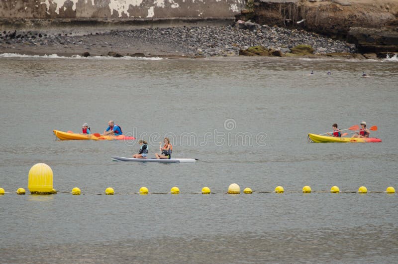 Los Cristianos, October 24, 2021: People kayaking in the coast of Tenerife. Canary Islands. Spain. Los Cristianos, October 24, 2021: People kayaking in the coast of Tenerife. Canary Islands. Spain.