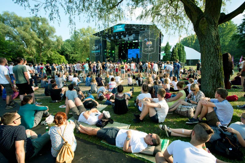 KATOWICE, POLAND: People sit on the grass and have rest on outdoor party on green area of music festival OFF. Katowice lies within an urban zone with population of 2,746,460. KATOWICE, POLAND: People sit on the grass and have rest on outdoor party on green area of music festival OFF. Katowice lies within an urban zone with population of 2,746,460