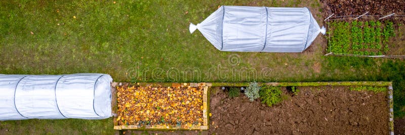 Luftbild von düsteren, niedrigen Tunnelgrünhäusern in einem Garten. Polytunnels Herbstgartenschutz bei kalten Witterungsbedingunge lizenzfreies stockbild