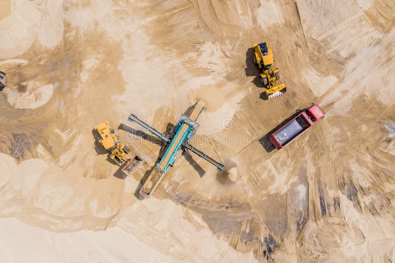 Aerial view of sand quarry with trucks and bulldozers. Heavy bulldozer loading  sand. Aerial view of sand quarry with trucks and bulldozers. Heavy bulldozer loading  sand