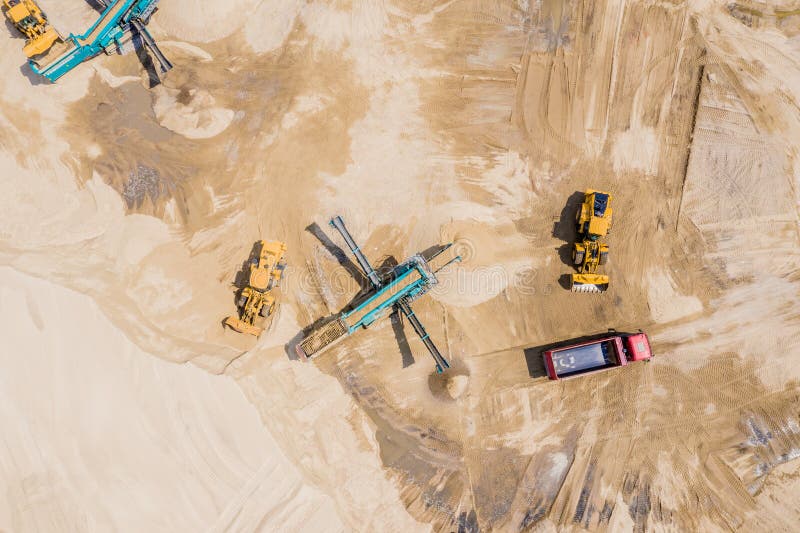 Aerial view of sand quarry with trucks and bulldozers. Heavy bulldozer loading  sand. Aerial view of sand quarry with trucks and bulldozers. Heavy bulldozer loading  sand