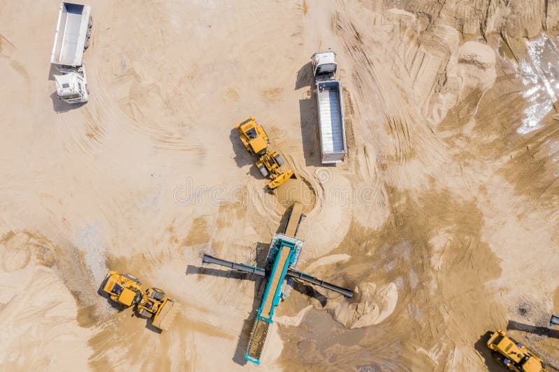 Aerial view of sand quarry with trucks and bulldozers. Heavy bulldozer loading  sand. Aerial view of sand quarry with trucks and bulldozers. Heavy bulldozer loading  sand