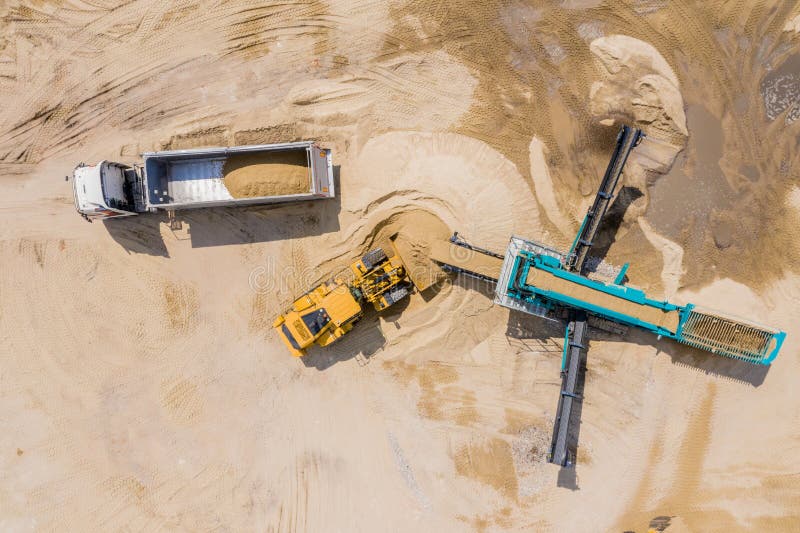 Aerial view of sand quarry with trucks and bulldozers. Heavy bulldozer loading  sand. Aerial view of sand quarry with trucks and bulldozers. Heavy bulldozer loading  sand