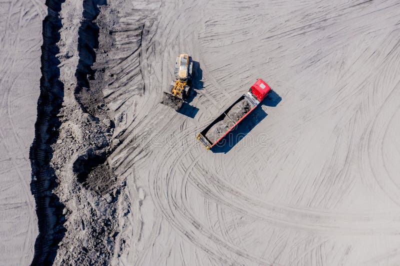 Aerial view of sand quarry with trucks and bulldozers. Heavy bulldozer loading  sand. Aerial view of sand quarry with trucks and bulldozers. Heavy bulldozer loading  sand