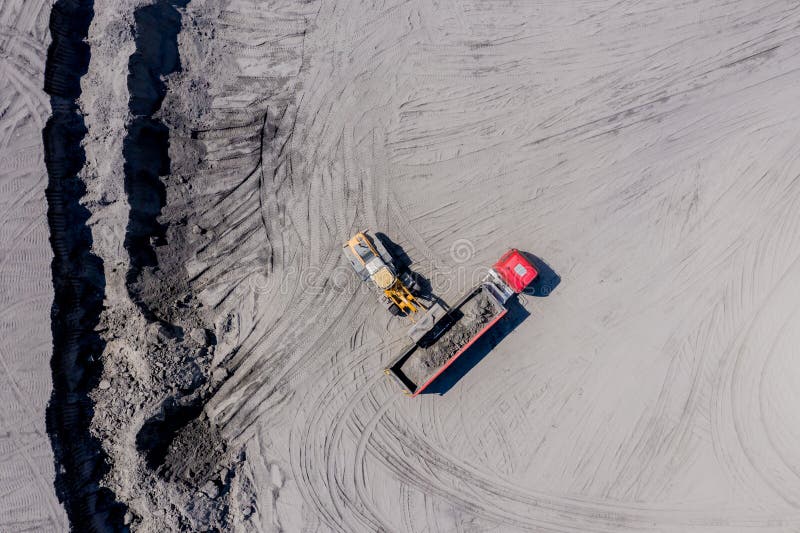 Aerial view of sand quarry with trucks and bulldozers. Heavy bulldozer loading  sand. Aerial view of sand quarry with trucks and bulldozers. Heavy bulldozer loading  sand