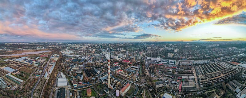 Aerial drone view of Chisinau at sunset. Panorama view of multiple buildings, thermal station, roads with moving cars, bare trees. Moldova. Aerial drone view of Chisinau at sunset. Panorama view of multiple buildings, thermal station, roads with moving cars, bare trees. Moldova