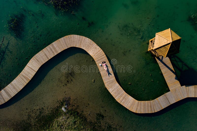 Luftbrummenansichtfrau im Badeanzug ein Sonnenbad nehmend auf dem Pier lizenzfreies stockbild Luftbrummenansichtfrau im Badeanzug ein Sonnenbad nehmend auf dem Pier lizenzfreies stockbild