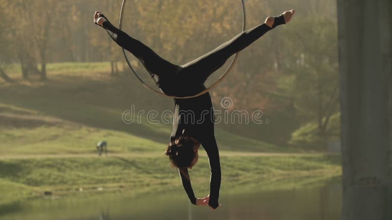 Luftgymnastikkvinnan utför akrobatiktrick på flyg- beslag i ultrarapid