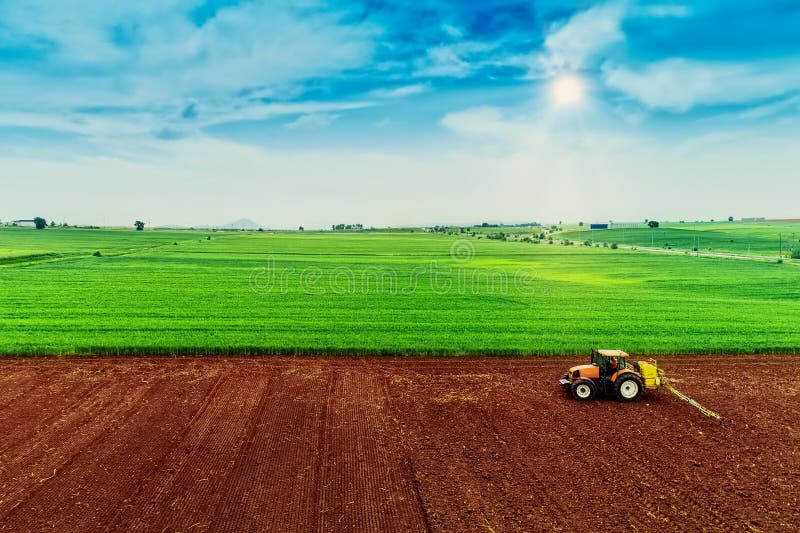 Aerial shot of Farmer with a tractor on the agricultural field sowing. tractors working on the agricultural field in spring. Cotton seed. Aerial shot of Farmer with a tractor on the agricultural field sowing. tractors working on the agricultural field in spring. Cotton seed