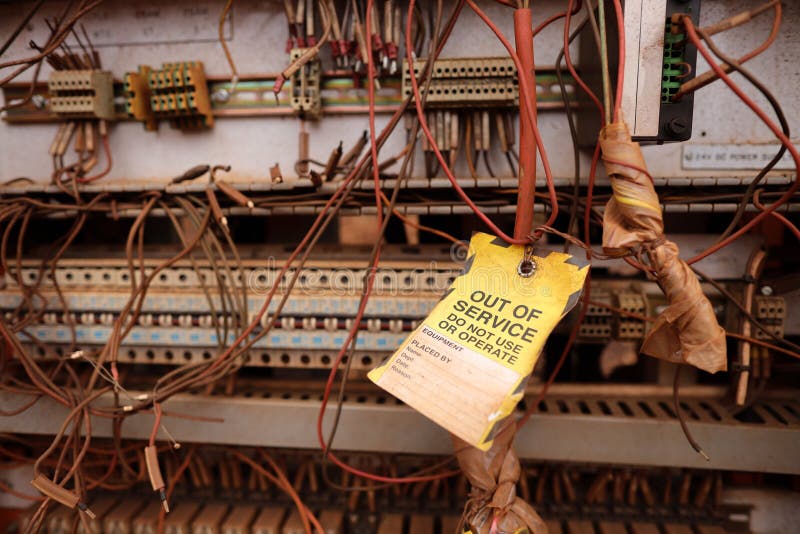 Lugar de trabajo seguro amarillo fuera de servicio etiqueta colocada en el cable de cable eléctrico industrial como equipo de daño