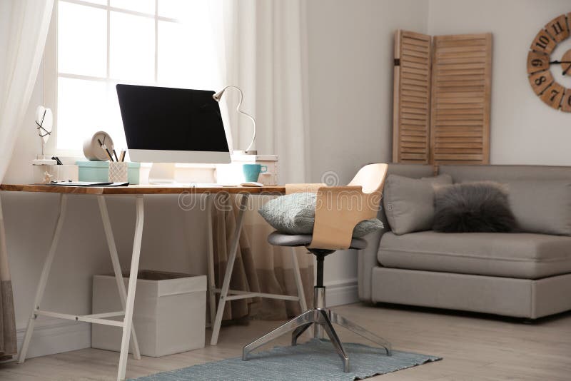 Lugar de trabalho claro com o computador perto da janela em casa interior imagem de stock Lugar de trabalho claro com o computador perto da janela em casa interior imagem de stock
