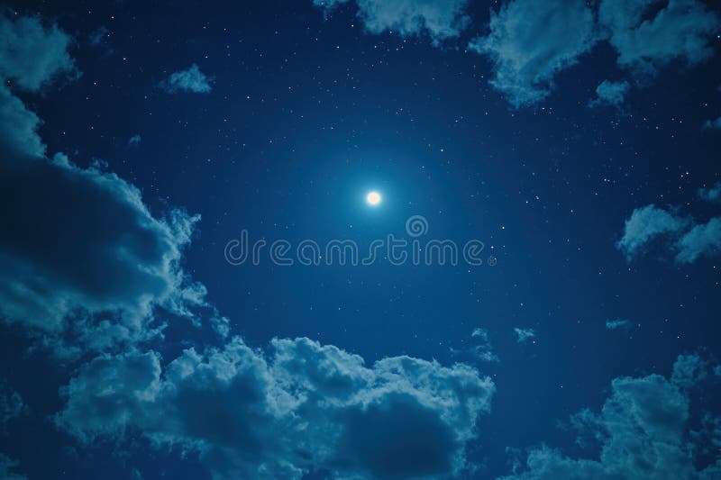 A luminous full moon surrounded by a clear starry night sky with soft, scattered clouds creating a serene and tranquil stock photos
