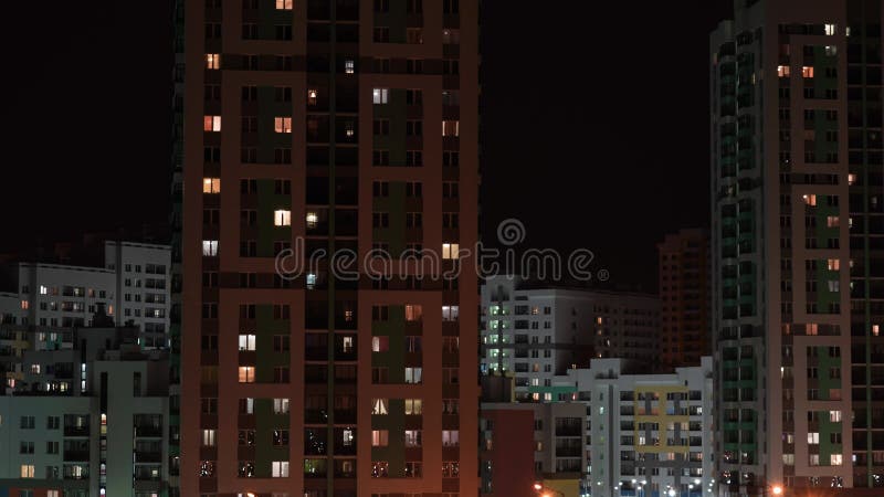 Lumière de nuit dans les fenêtres d'un bâtiment à plusieurs étages banque de vidéos