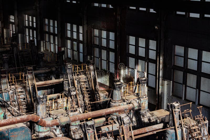 Lumière du soleil illuminant de vieilles machines de formation en acier à l'intérieur d'un entrepôt windowed photo stock Lumière du soleil illuminant de vieilles machines de formation en acier à l'intérieur d'un entrepôt windowed photo stock