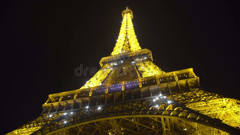 Lumières lumineuses clignotant sur la construction de Tour Eiffel, nuit romantique à Paris