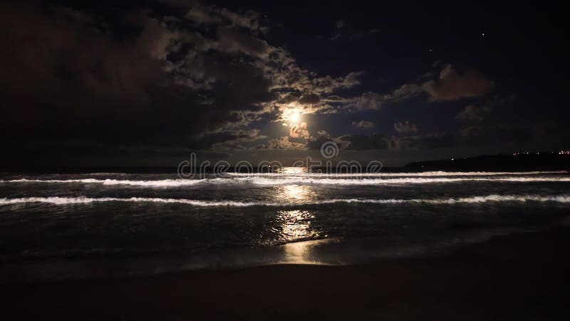 Luna llena surgiendo sobre olas de mar. dramática puesta de sol sobre el video de la playa