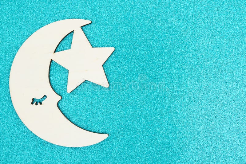 Luna y estrella de madera en un fondo del brillo de la turquesa foto de archivo Luna y estrella de madera en un fondo del brillo de la turquesa foto de archivo