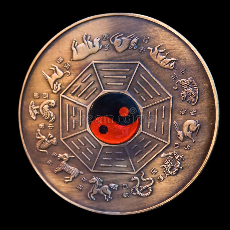 Calendario lunare raffigurato in un medaglione di bronzo con il rosso e il nero ying yang nel mezzo, isolato su nero.