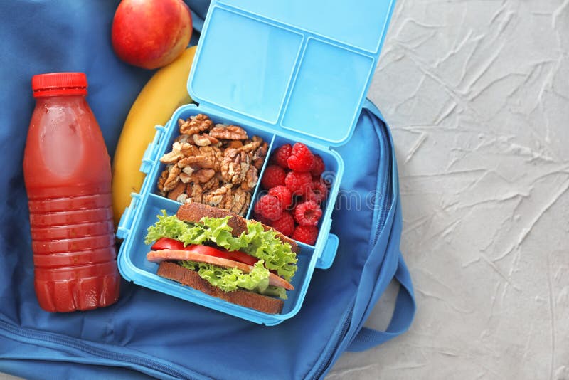 Lunch Box with Appetizing Food and Bottle of Juice on Bag Stock Photo
