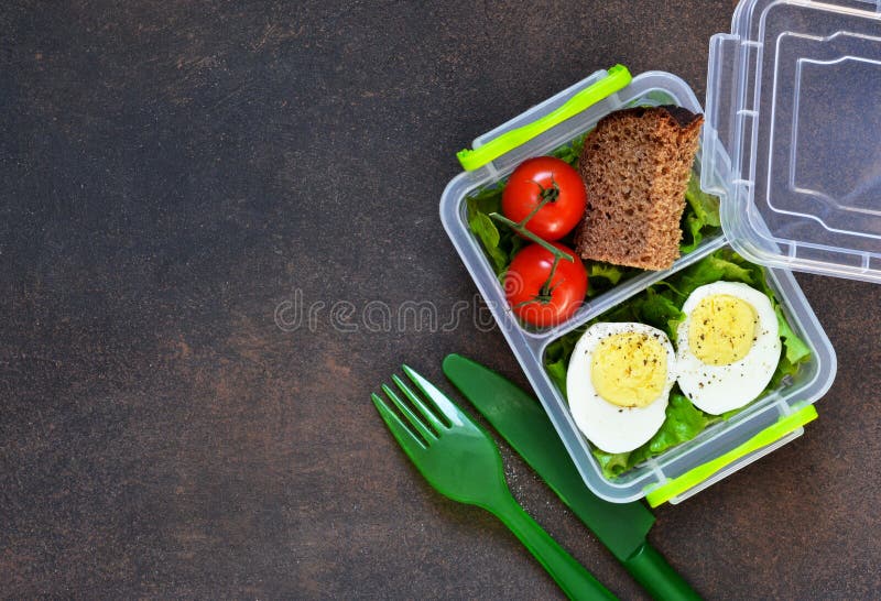 Lunch Box with Egg, Tomato, Salad and Sandwich. View from Above Stock
