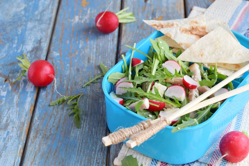 Lunch Box with salad of fresh vegetables - arugula, radish, feta cheese, ham and sesame with flat bread tortilla. Healthy food. royalty free stock photo Lunch Box with salad of fresh vegetables - arugula, radish, feta cheese, ham and sesame with flat bread tortilla. Healthy food. royalty free stock photo