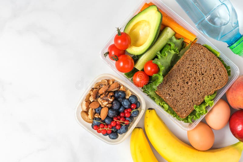 Lunch boxes with food ready to go for work or school. sandwich, vegetables, avocado, nuts, berries, eggs and water royalty free stock photo Lunch boxes with food ready to go for work or school. sandwich, vegetables, avocado, nuts, berries, eggs and water royalty free stock photo