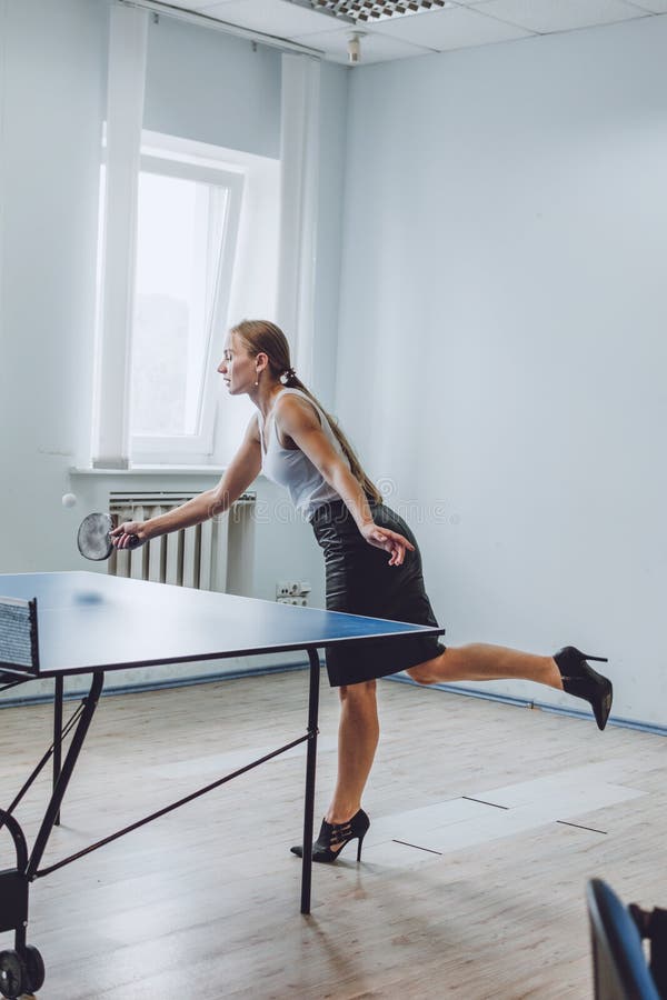 Lunch break activities concept. Office games during Lunch break. Attractive young Business woman playing ping pong, table tennis