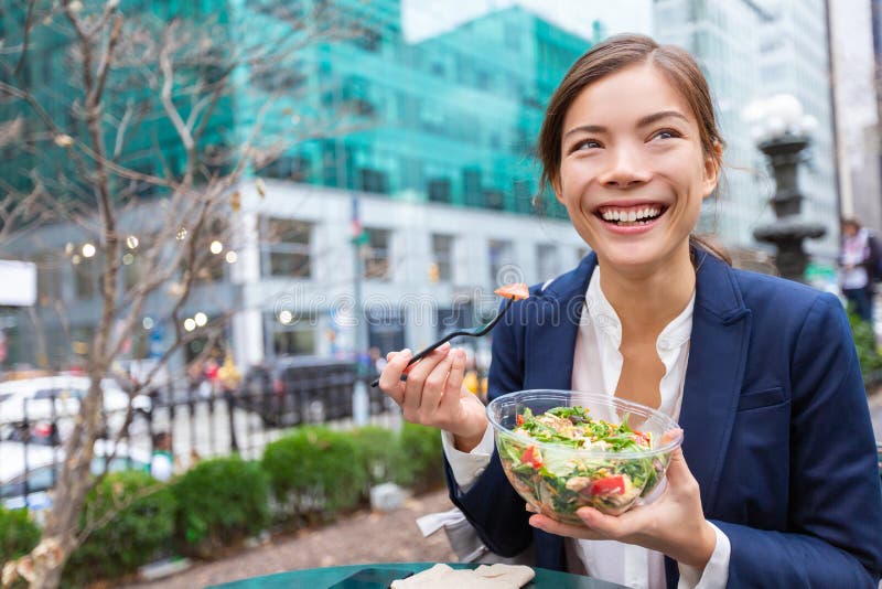 Lunch salad take out bowl healthy eating Asian business woman ready to eat in City Park living lifestyle . Happy smiling